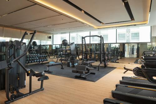 a gym with lots of treadmills and machines at Valia Hotel Bangkok in Bangkok