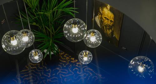 a group of lights hanging from a ceiling with a plant at HOTEL VIENA in Satu Mare