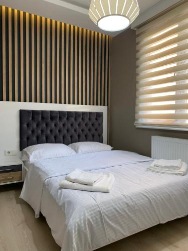 een slaapkamer met een groot bed en 2 handdoeken bij Alfa Toplu ulaşıma yakın Tam donanımlı şık daire in Istanbul
