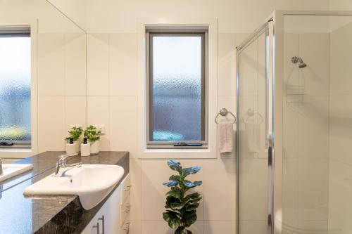 ein Bad mit einem Waschbecken und einer Dusche in der Unterkunft Beach Retreat in Saint Leonards