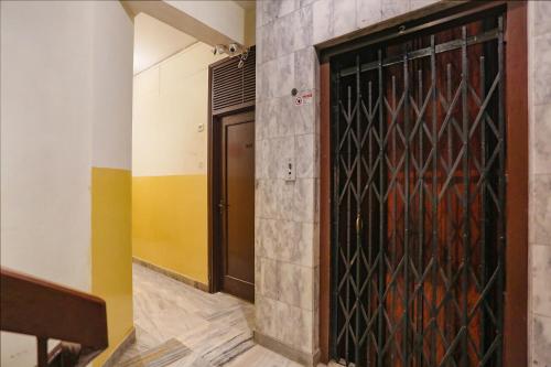 a door in a room with a wall with a painting on it at FabHotel Ashoka Inn in Kānpur