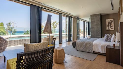 a bedroom with a bed and a view of the ocean at UMITO Okinawa Onnason in Onna