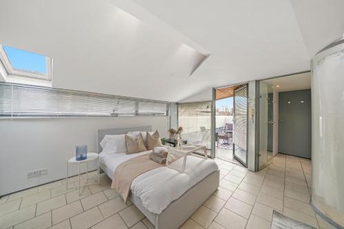 a bedroom with a large bed and a balcony at Livestay-Camden Mews House with Private Roof Terrace in London