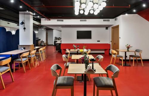 uma sala de jantar com mesas e cadeiras e uma televisão de ecrã plano em Graf Hotel em Tbilisi