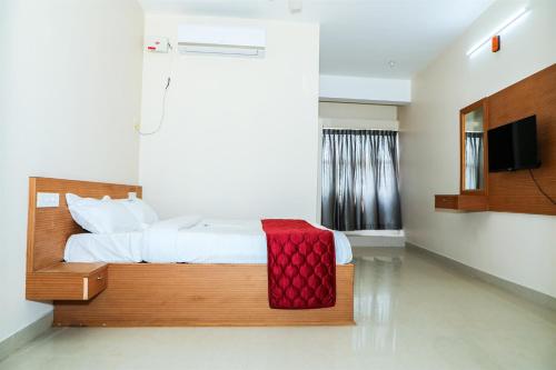 a bedroom with a large bed and a television at KKM International kk in Kanyakumari