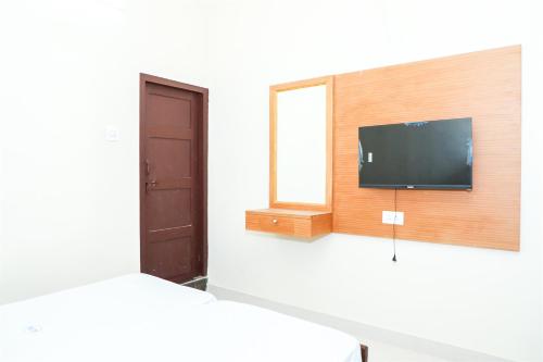 a room with a flat screen tv and a window at KKM International kk in Kanyakumari