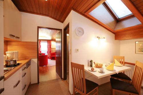 - une cuisine et une salle à manger avec une table et des chaises dans l'établissement Appartement Lackner, à Zell am See