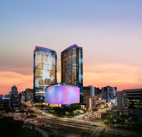 un perfil urbano con rascacielos altos al atardecer en Grand Hyatt Jeju en Jeju