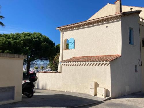 a motor scooter parked next to a white building at Maison du pêcheur bord de mer - 2 à 4 pers in Saint-Raphaël