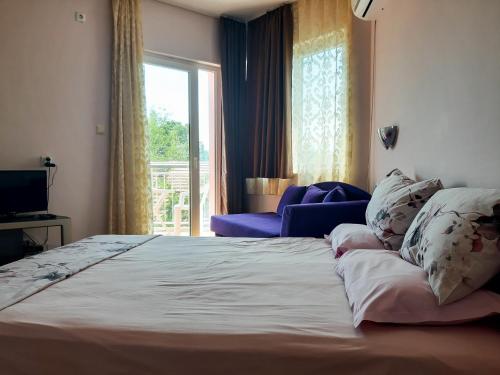 a bedroom with a large bed and a window at House Rezvaya with rooms for rent in Rezovo
