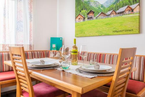 a wooden table with glasses and a bottle of wine at Apartment Schlickenhof in Hintergöriach
