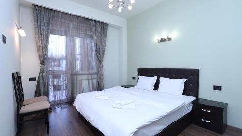 a bedroom with a large white bed and a window at Stay Inn apartments at Northern Avenue 5 in Yerevan