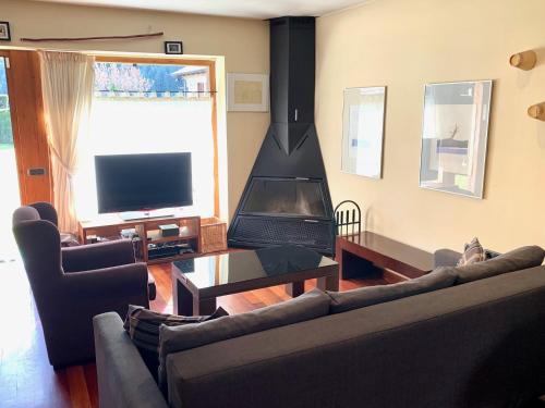 a living room with a couch and a fireplace at Casa Riu in Riu de Cerdanya