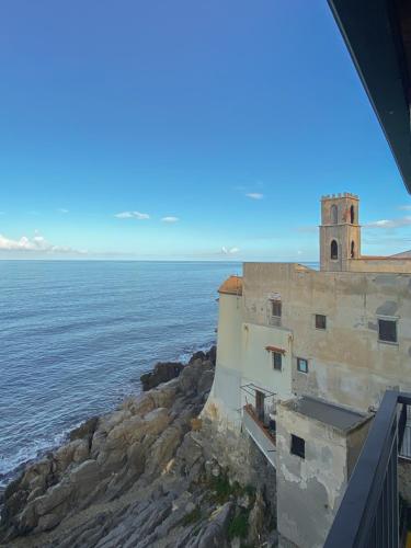 a building on a cliff next to the ocean at Terrazza Roberto in Cefalù