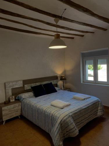 a bedroom with a large bed with a blue comforter at Casa Rural "La villa del pistacho" in Archivel