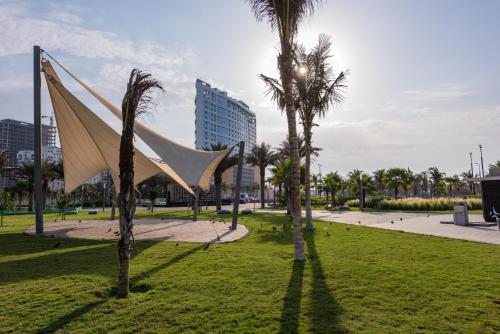 a sculpture in a park with palm trees at Seafront Luxury Suites Jeddah Corniche in Jeddah
