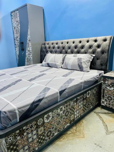 a bed in a room with a blue wall at Smart Stays - MMMUT College - GKP Airport in Gorakhpur