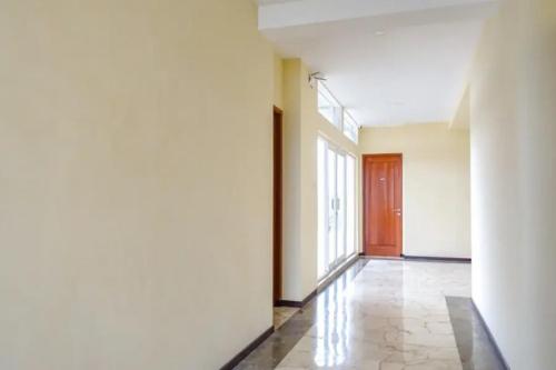 una stanza vuota con un corridoio con una porta di De Malang Sweet Homestay Syariah Mitra RedDoorz a Malang