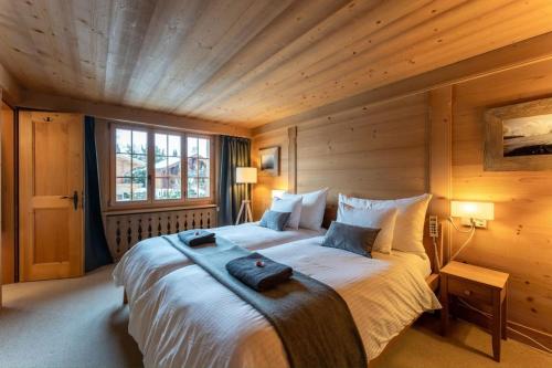 um quarto com uma cama grande num quarto de madeira em Charming Alpine Apartment Gstaad em Gstaad