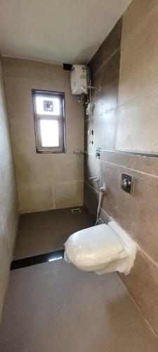 a small bathroom with a window and a toilet at RK island view villa in Dabolim