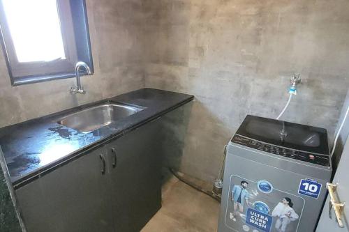 uma pequena cozinha com um lavatório e um fogão em RK island view villa em Dabolim