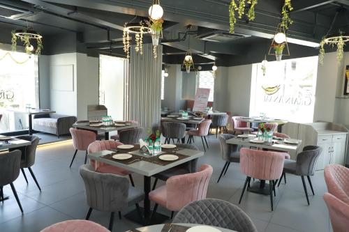 a dining room with tables and pink chairs at Jivanta Shirdi in Shirdi