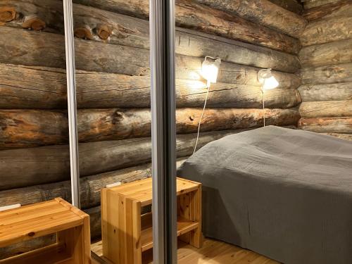 a bedroom with a bed and a wooden wall at RepoRuka in Ruka