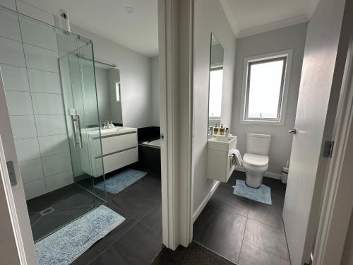 een badkamer met een douche, een toilet en een wastafel bij Home Away from Home in Napier