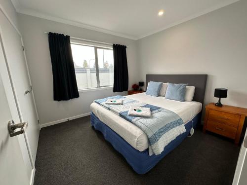 - une chambre avec un grand lit et une fenêtre dans l'établissement Home Away from Home, à Napier