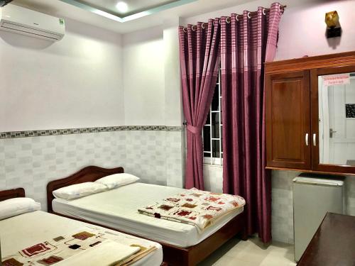 a small room with two beds and a window at 2001 Motel in Long Hai