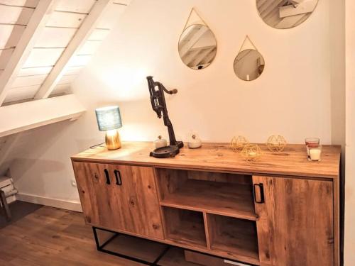 a desk with a lamp and mirrors on the wall at Appart de charme aux pieds des remparts, terrasse in Guérande