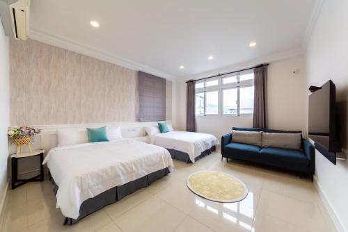 a hotel room with two beds and a couch at Romatic Venice Homestay in Luodong