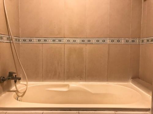 een wit bad in de badkamer bij khách sạn Hồng Tâm in Ho Chi Minh-stad