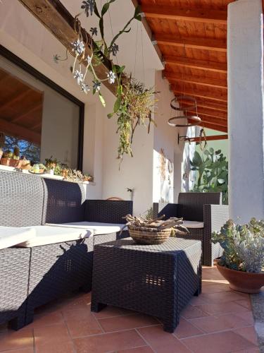 Ovodda的住宿－HomeRaffa，庭院设有藤椅和桌子。