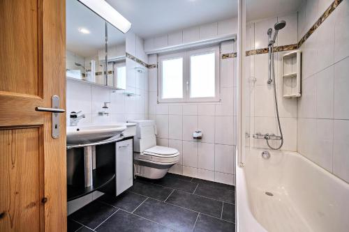 a bathroom with a sink and a toilet and a tub at Grabahus in Arosa