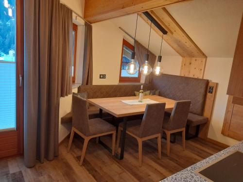 ein Esszimmer mit einem Holztisch und Stühlen in der Unterkunft Apart Alpen Royal in Nauders