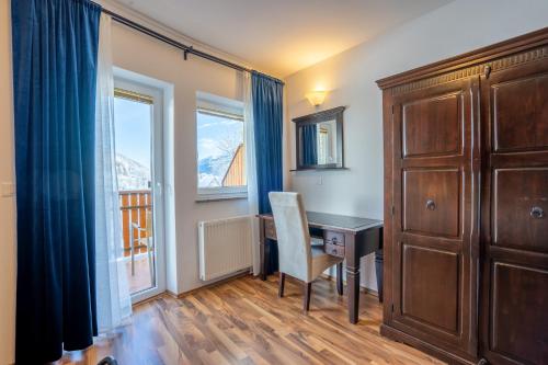 Zimmer mit einem Schreibtisch, einem Schrank und einem Fenster in der Unterkunft Apartments T E M P F E R 2 new 80 m2 WELLNESS in Kranjska Gora