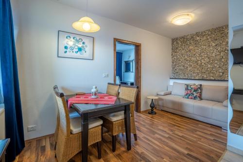 a dining room with a table and chairs and a couch at TEMPFER 2 Apartments & Rooms with new WELLNESS in Kranjska Gora