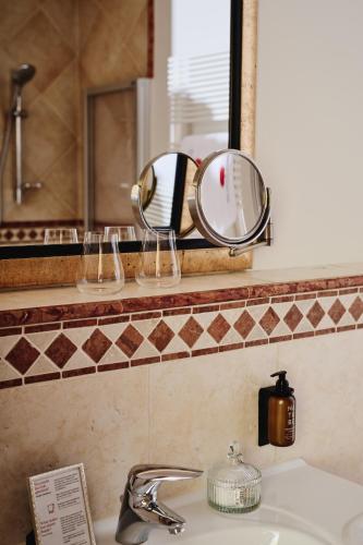 a mirror sitting on a shelf above a sink at Gut Stiluppe - 4 Sterne Superior Good Life Hotel in Mayrhofen