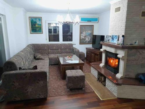 a living room with a couch and a fireplace at Peaceful house Velika Kladusa 1km from centre in Velika Kladuša