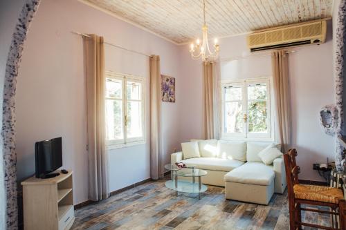 a living room with a couch and a tv at Villa Christa in Arillas