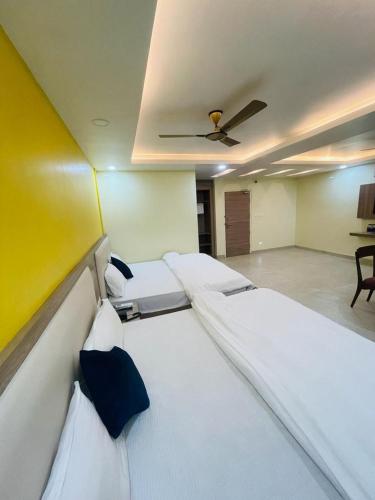 a room with three beds and a ceiling at Royal Beach International in Puri