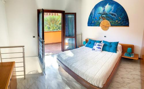 a bedroom with a large bed with blue pillows at Appartamenti La Casina in Porto Azzurro