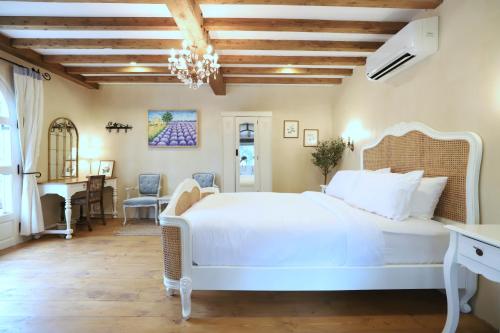a bedroom with a large white bed and a desk at Moon River Village in Ban Bu Khanun