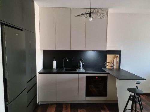 a kitchen with white cabinets and a black counter top at Copper Apartment Free Parking in Wrocław