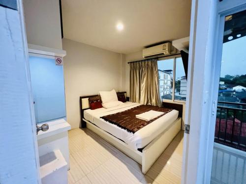 Habitación pequeña con cama y ventana en INN Kham Apartment, en Chiang Mai