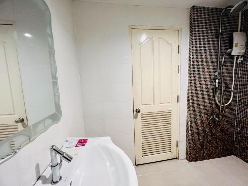 a bathroom with a sink and a mirror and a shower at INN Kham Apartment in Chiang Mai