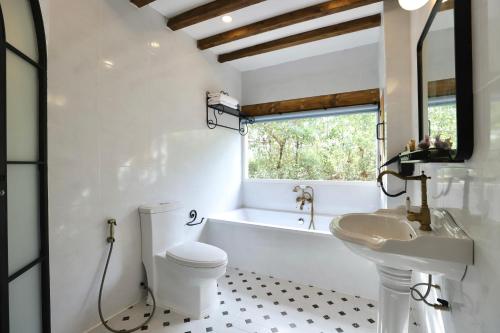 een badkamer met een bad, een toilet en een wastafel bij Moon River Village in Ban Bu Khanun