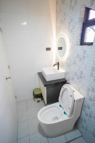 a white bathroom with a toilet and a sink at Balay Greenika Tagaytay Private Pool in Tagaytay