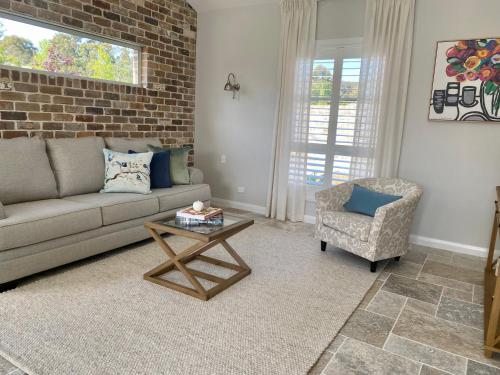 a living room with a couch and a chair at Bloomfield Manor in Bowral